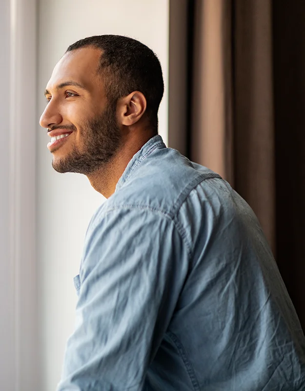 Man looking out a window smiling