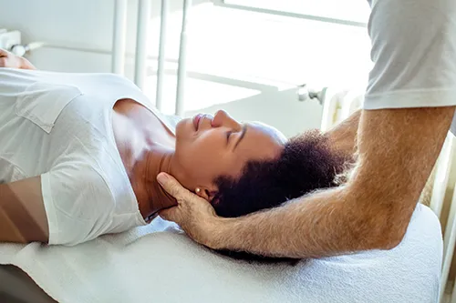 Chiropractor helping a woman with head pain