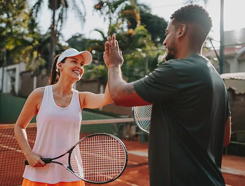 Two tennis players giving each other a high five